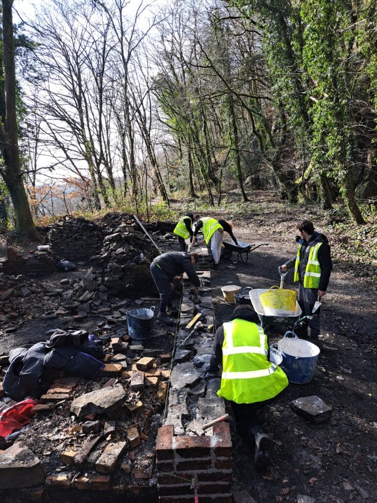 An image of a group of people repairing a wall at Craig Gwladus Country Park.